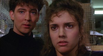 Movie still from “Hellraiser” (1987), directed by Clive Barker – A man and a woman looking at the camera; Close Up shot, Over the shoulder angle