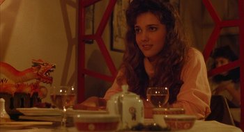 Movie still from “Hellraiser” (1987), directed by Clive Barker – A woman sitting at a table with a glass of wine; Close Up shot, Over the shoulder angle
