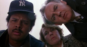 Movie still from “Hellraiser” (1987), directed by Clive Barker – A group of people standing next to each other in front of a wall; Close Up shot, Low angle