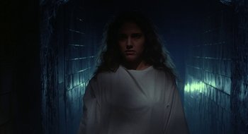 Movie still from “Hellraiser” (1987), directed by Clive Barker – A woman in a white shirt standing in a dark room; Medium shot, Low angle