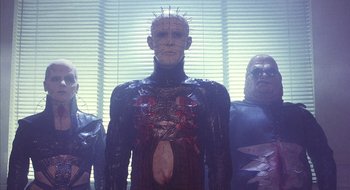 Movie still from “Hellraiser” (1987), directed by Clive Barker – A group of men standing next to each other; Medium shot, Low angle