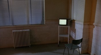 Movie still from “Hellraiser” (1987), directed by Clive Barker – An empty room with a television set on the floor; Wide shot, High angle