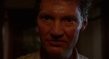 Movie still from “Hellraiser” (1987), directed by Clive Barker – A man's face in a dark room; Close Up shot, Low angle