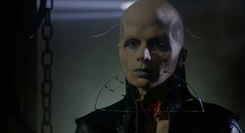 Movie still from “Hellraiser” (1987), directed by Clive Barker – A man with a bald head is standing in front of a mirror; Close Up shot, Low angle