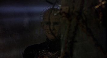 Movie still from “Hellraiser” (1987), directed by Clive Barker – A man with a pinhead head in a dark room; Close Up shot, Low angle