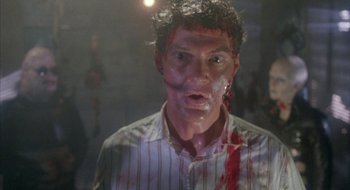 Movie still from “Hellraiser” (1987), directed by Clive Barker – A man with blood all over his face; Close Up shot, Over the shoulder angle