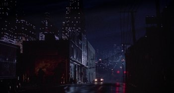 Movie still from “Hellraiser III: Hell on Earth” (1992), directed by Anthony Hickox – A car is driving down the street at night; Extreme Wide shot, High angle