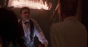 Movie still from “Hellraiser III: Hell on Earth” (1992), directed by Anthony Hickox – A man wearing a white shirt and a bow tie; Medium shot, Over the shoulder angle