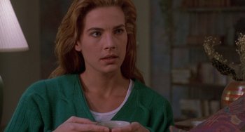 Movie still from “Hellraiser III: Hell on Earth” (1992), directed by Anthony Hickox – A woman in a green shirt is holding a white cup; Close Up shot, Over the shoulder angle