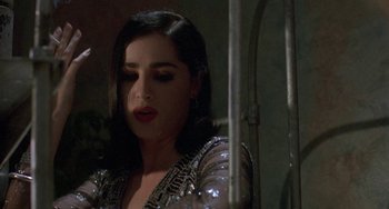 Movie still from “Hellraiser III: Hell on Earth” (1992), directed by Anthony Hickox – A woman with dark hair wearing a sequined top; Close Up shot, Over the shoulder angle