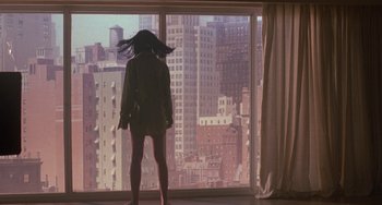Movie still from “Hellraiser III: Hell on Earth” (1992), directed by Anthony Hickox – A woman standing in front of a large window looking out at a city; Wide shot, Low angle