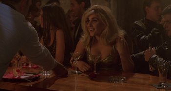 Movie still from “Hellraiser III: Hell on Earth” (1992), directed by Anthony Hickox – A woman sitting at a table holding a wine glass; Medium shot, Over the shoulder angle