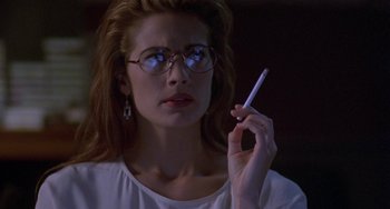 Movie still from “Hellraiser III: Hell on Earth” (1992), directed by Anthony Hickox – A woman with glasses is holding a cell phone; Close Up shot, Low angle