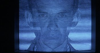 Movie still from “Hellraiser III: Hell on Earth” (1992), directed by Anthony Hickox – A man's face in front of a projector screen; Extreme Close Up shot, Low angle