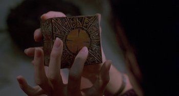 Movie still from “Hellraiser III: Hell on Earth” (1992), directed by Anthony Hickox – A person holding an object in their hands; Extreme Close Up shot, Overhead angle