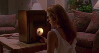 Movie still from “Hellraiser III: Hell on Earth” (1992), directed by Anthony Hickox – A beautiful young lady sitting in front of an old radio; Medium shot, Low angle