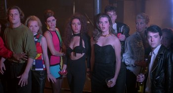 Movie still from “Hellraiser III: Hell on Earth” (1992), directed by Anthony Hickox – A group of people standing next to each other holding drinks; Medium shot, High angle