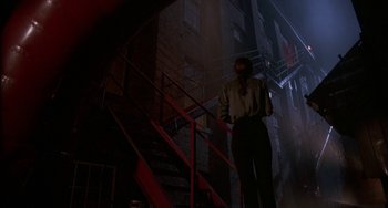 Movie still from “Hellraiser III: Hell on Earth” (1992), directed by Anthony Hickox – A man standing on the stairs of a building; Wide shot, Low angle