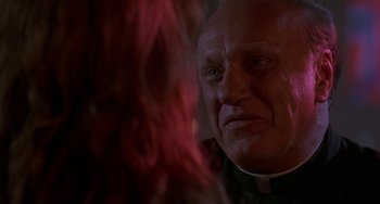Movie still from “Hellraiser III: Hell on Earth” (1992), directed by Anthony Hickox – An older man wearing a priest's outfit stares at the camera; Close Up shot, Low angle