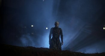 Movie still from “Hellraiser III: Hell on Earth” (1992), directed by Anthony Hickox – A man with a mask standing on top of a hill; Wide shot, Low angle
