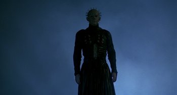 Movie still from “Hellraiser III: Hell on Earth” (1992), directed by Anthony Hickox – A man in a black dress with a spiky head; Medium shot, Low angle