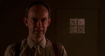 Movie still from “Hellraiser III: Hell on Earth” (1992), directed by Anthony Hickox – A man in a brown shirt and a brown tie; Close Up shot, Low angle