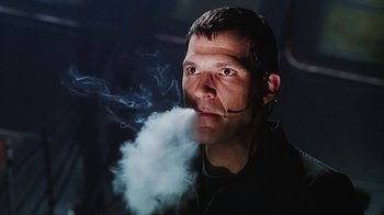 Movie still from “Hellraiser: Bloodline” (1996), directed by Kevin Yagher – A man smoking a cigarette while holding a cell phone; Close Up shot, Low angle
