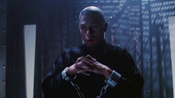 Movie still from “Hellraiser: Bloodline” (1996), directed by Kevin Yagher – A man in a black shirt is chained up; Close Up shot, Low angle