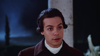 Movie still from “Hellraiser: Bloodline” (1996), directed by Kevin Yagher – A young man with long dark hair wearing a brown jacket; Close Up shot, High angle
