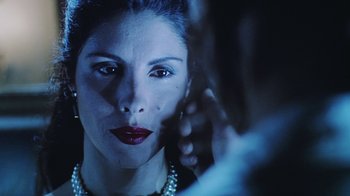 Movie still from “Hellraiser: Bloodline” (1996), directed by Kevin Yagher – A person wearing a pearl necklace; Close Up shot, Over the shoulder angle