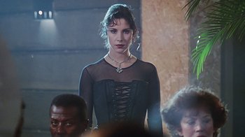 Movie still from “Hellraiser: Bloodline” (1996), directed by Kevin Yagher – A woman in a black dress standing in front of other people; Medium shot, Over the shoulder angle