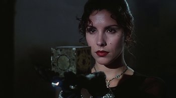 Movie still from “Hellraiser: Bloodline” (1996), directed by Kevin Yagher – A beautiful woman holding a clock in a dark room; Close Up shot, Low angle