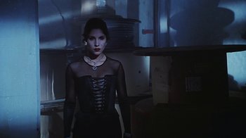 Movie still from “Hellraiser: Bloodline” (1996), directed by Kevin Yagher – A woman in a black dress standing in a dark room; Medium shot, Low angle