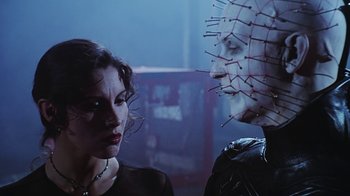 Movie still from “Hellraiser: Bloodline” (1996), directed by Kevin Yagher – A woman standing next to a man with a pinhead mask on; Close Up shot, Low angle