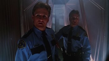 Movie still from “Hellraiser: Bloodline” (1996), directed by Kevin Yagher – Two men in police uniforms standing next to each other; Medium shot, Low angle