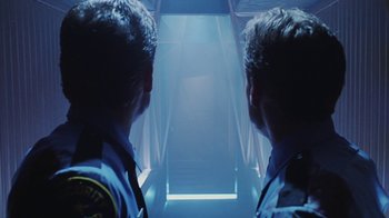 Movie still from “Hellraiser: Bloodline” (1996), directed by Kevin Yagher – Two police officers looking into a stairwell in a building; Medium shot, Low angle