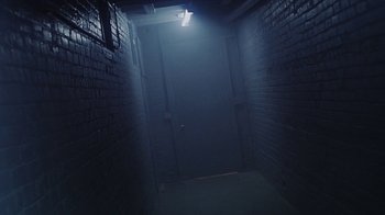 Movie still from “Hellraiser: Bloodline” (1996), directed by Kevin Yagher – A dark hallway with a light shining on the door; Wide shot, High angle