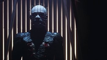 Movie still from “Hellraiser: Bloodline” (1996), directed by Kevin Yagher – A man in a black jacket with spikes on his head; Close Up shot, Low angle