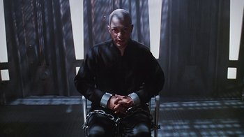 Movie still from “Hellraiser: Bloodline” (1996), directed by Kevin Yagher – A man sitting in a chair with his hands chained; Medium shot, High angle