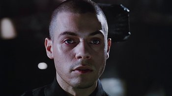 Movie still from “Hellraiser: Bloodline” (1996), directed by Kevin Yagher – A person wearing a black shirt; Close Up shot, Low angle