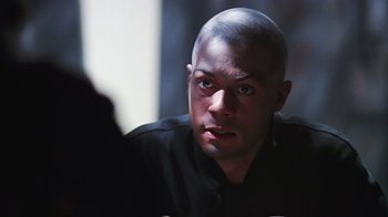 Movie still from “Hellraiser: Bloodline” (1996), directed by Kevin Yagher – A man with a shaved head looking at the camera; Close Up shot, Over the shoulder angle