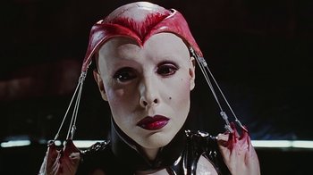Movie still from “Hellraiser: Bloodline” (1996), directed by Kevin Yagher – A woman in a leather outfit and a red hat; Close Up shot, Low angle