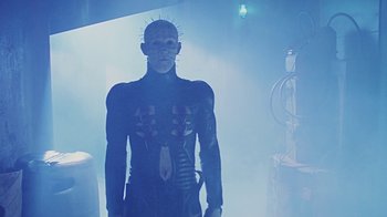 Movie still from “Hellraiser: Bloodline” (1996), directed by Kevin Yagher – A man in a body suit with a pinhead on his head; Medium shot, Low angle