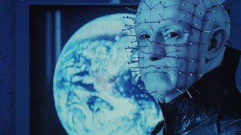 Movie still from “Hellraiser: Bloodline” (1996), directed by Kevin Yagher – A man's face in front of a globe; Close Up shot, Low angle