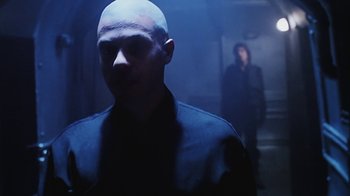 Movie still from “Hellraiser: Bloodline” (1996), directed by Kevin Yagher – A man standing in a dark room next to a woman; Close Up shot, Over the shoulder angle