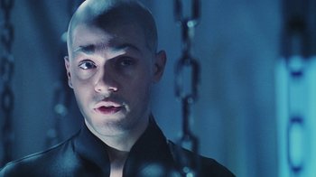 Movie still from “Hellraiser: Bloodline” (1996), directed by Kevin Yagher – A man with a shaved head and a chain around his neck; Close Up shot, Low angle