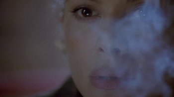 Movie still from “Hellraiser: Deader” (2005), directed by Rick Bota – A woman's face with smoke billowing out of her mouth; Extreme Close Up shot, Overhead angle