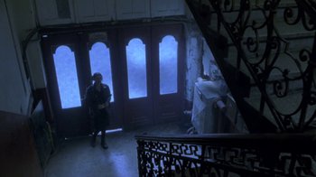 Movie still from “Hellraiser: Deader” (2005), directed by Rick Bota – A woman standing in front of an open door; Extreme Wide shot, High angle
