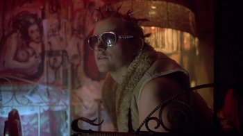 Movie still from “Hellraiser: Deader” (2005), directed by Rick Bota – A man with a beard and glasses in a room with graffiti on the walls; Close Up shot, Low angle