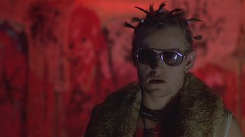 Movie still from “Hellraiser: Deader” (2005), directed by Rick Bota – A man wearing sunglasses and a fur coat; Close Up shot, Low angle